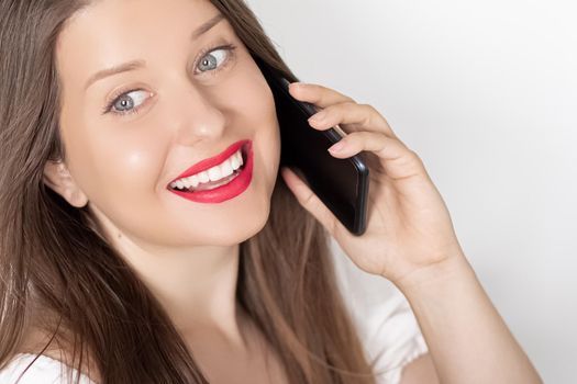 Happy smiling woman calling on smartphone, portrait on white background. People, technology and communication concept.