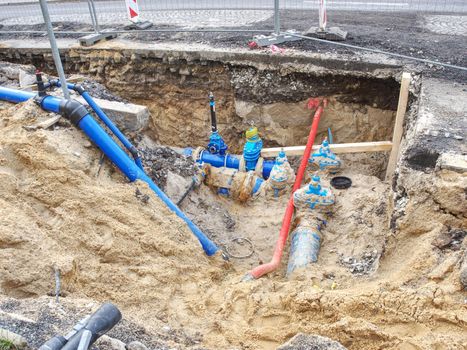 Valve and HDPE pipe welded underground. City potable water system. MAn water supply plastic tubes, excavation pit