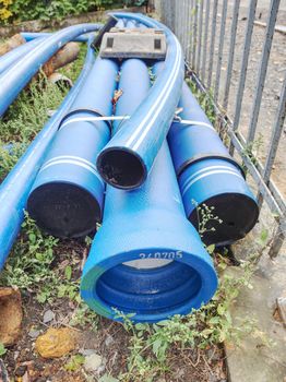 New blue pipes or tubes. Fluid conveyance. Pipeline construction. Pipes fastened with plastic tape