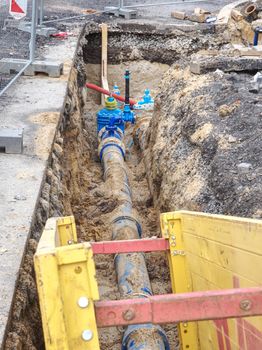 Steel temporary shuttering for cement filling.  Construction of concrete formwork with panel forms below street asphalt. Water supply system repairing.