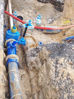 Drink Water Delivering in steel and PVC Plastic Pipes in Ground Hole during Plumbing. Blue tube junction. Bury Tube for water transport