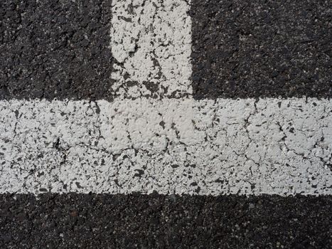White paint line on old obsolete asphalt plaground. Empty kids areal.