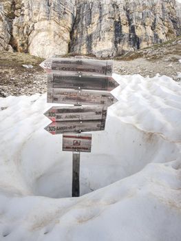 Wooden sign on a trekking path at the Dolomites mountains. Tre Cime di Lavaredo tour