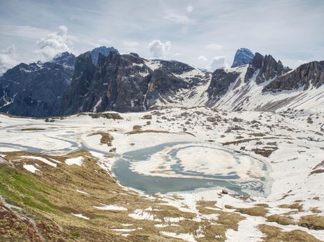 View over Alpine valley to sharp Alps peaks . Mountains increased from cloudy background