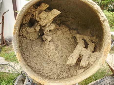 Mix of wet cement concrete in mobile mixer. Concrete mixing for building in detail. 