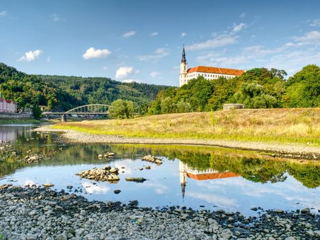 Dry riverbed of river Elbe in Decin, Czech Republic, summer 2018. Empty river bed with poisoned muddy water. Decin castle above old railway bridge.