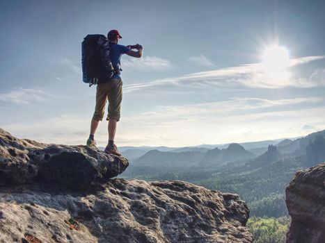 Hikers hands and phone, beautiful sunset morning, hiking middle age man standing looking at something