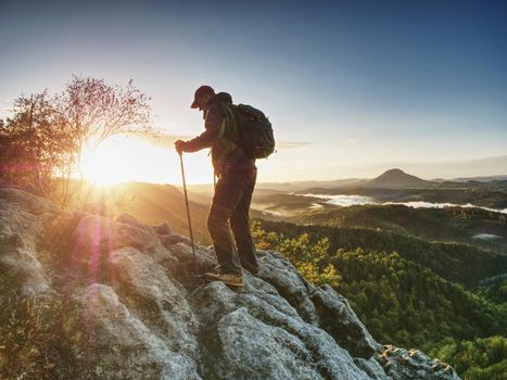 Man in rocks. Climbing hiking silhouette in fall mountains.  The climber in inspirational sunrise landscape on mountain peak. 