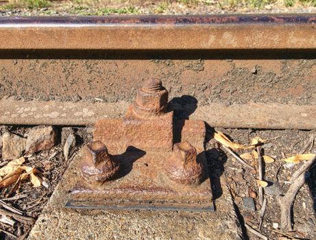 ap with nut and screw on the old rusty rail. Rusty train railway detail, oiled sleepers and stones between rail way 