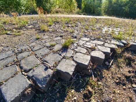 Grey Old Stone Pavement Top View or Granite Cobblestone Road. Hard granite stone blocks of cubic 