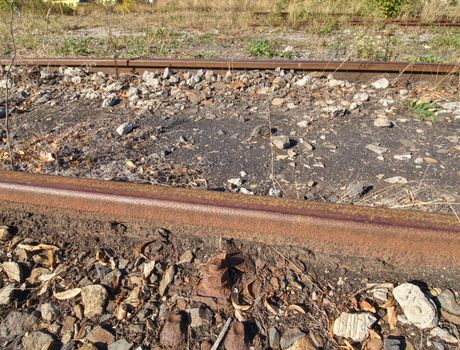 Close view of railroad track old fashioned rusty clamps and screws wooden railroad.