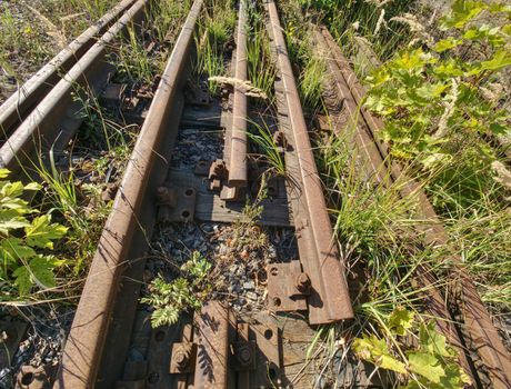 Close view of railroad track old fashioned rusty clamps and screws wooden railroad.