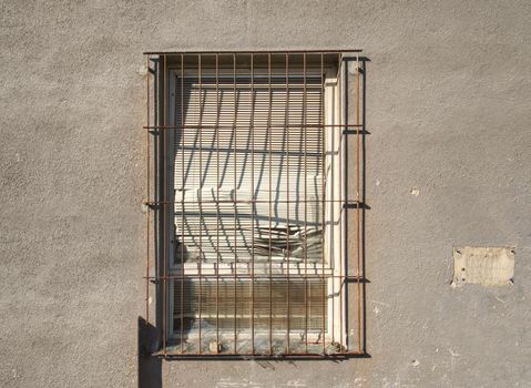 Old brick-lined window in old abandoned house. Old architecture. Old windows with rusty bars