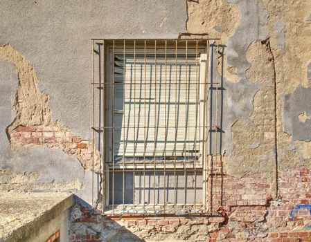 Old brick-lined window in old abandoned house. Old architecture. Old windows with rusty bars