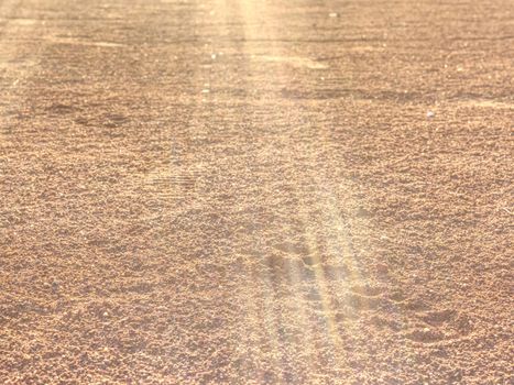 Footprints and service marks on tennis court details. Dry light red crushed bricks surface on outdoor tennis ground. Rough texture against sun