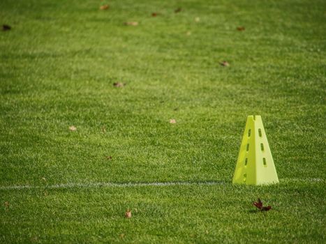 yellow triangles used as soccer training equipment on green grass field