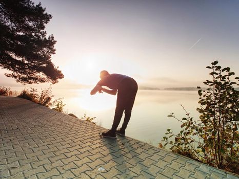 Sportsman using fitness bracelet. Trail runner athlete using his smart watch app to monitor fitness progress or heart rate during run cardio workout.