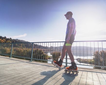 Doksy range, Czech Republic, 9th of October 2018. Inlines speed skater with shorts stretching legs before trick. .