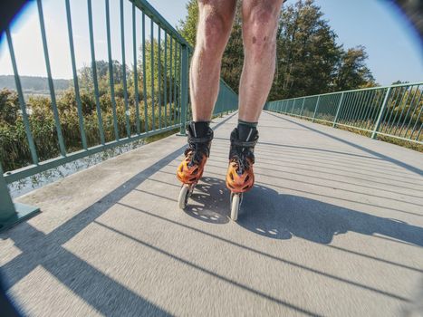 Doksy range, Czech Republic, 9th of October 2018. Roller skater ride in park. Boy legs in in-line hard shell boots blades.