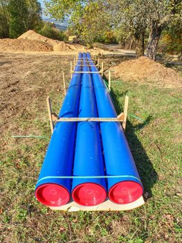 Long plastic tube on ground. Colorful thick wall of plastic pipe, bllue light and red circle end cover