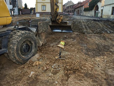 Potable water pipes rebuilding. Excavator performs work on the construction site of old town potable water system