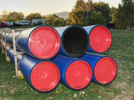 HDPE pipe for water supply stacked at building site  on ground under the open sky.  New branch of portable water for city. Construction site with machinery