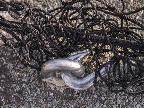 Steel turnbuckle and steel  sling anchored safety net into concrete block.