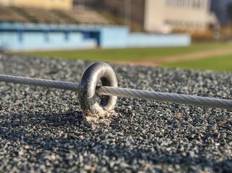 Steel twisted rope and steel bolt anchor eye in concrete base. The end knot of steel rope. 