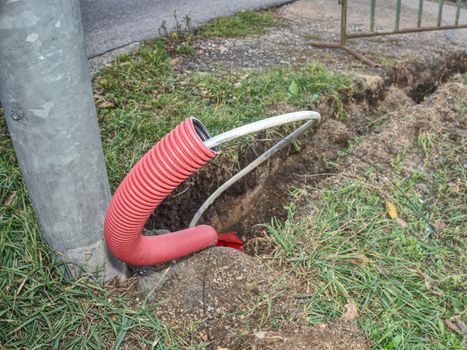 Detail of PVC ribbed tube ready for using under ground, leaves on wet siol.