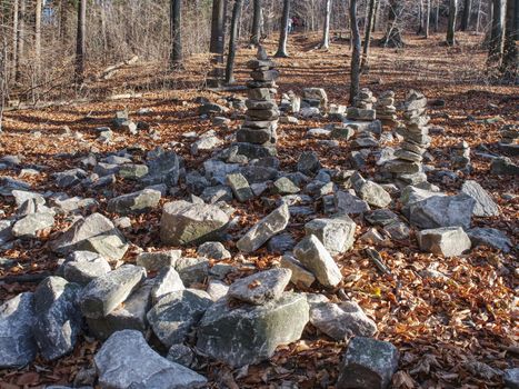 Sharp stones stacked in fall Forest . Moody autumn morning walk in park.