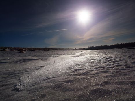 Snow with light reflections from cold winter sun. Snowflakes and shadows detail