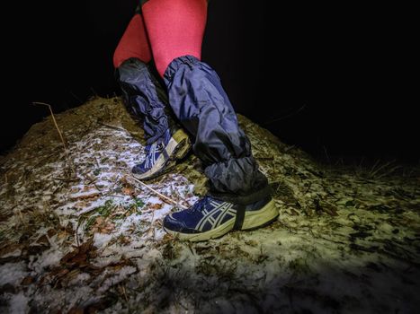 Winter night extreme runner control map.  January 25th 2019, Novy Bor, Czech Republic. Girl in forest reading map and checking a control point. Selective focus