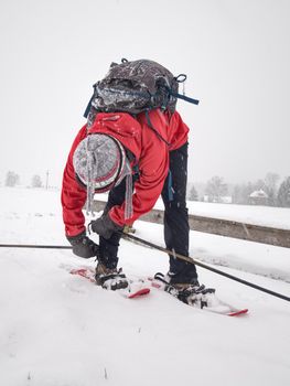 Smile face sports girl walk in snow shoes on snow cover meadow. 