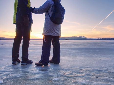 Couple, man and woman walking on the ice on a frozen lake. Happy couple on a frozen lake on a winter day