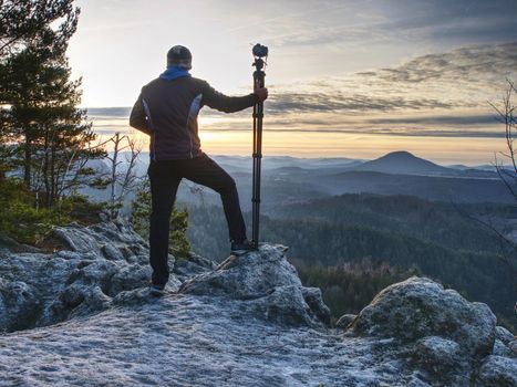 Hiker admiring the stunning misty mountain range, sunny morning. Epic travel in a wilderness,