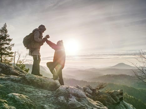 Pair of travelers  on peak trail. Two photographers, a man and woman taking sunrise pictures