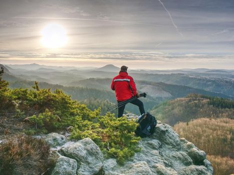 Tourist hold travel tripod. Photographer climbed on peak for photographing the sunrise on the top of the mountain