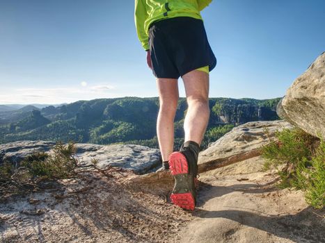 Runner workout outdoor in rocks  during trail marathon on mountain path. Sunny flares on amazing nature