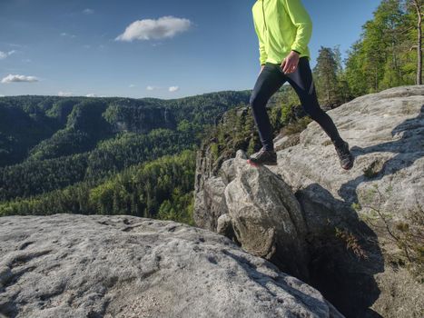 Man athlete while jumping during a trail running in the mountains. Active Lifestyle and Adventure Concept