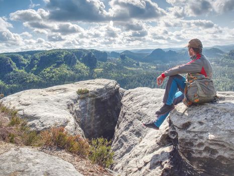 Tourist man looking at view of  far mountains, Norway. Hikking, relax on trip