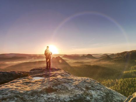 Pretty woman  enjoys the view of sunset over an autumn forest in deep velly bellow. Enjoy moment ot of people