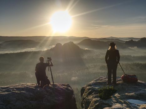 Two photographers discuss and share my experiences. Artists make amazing photos on a ledge above the daybreak pure nature.