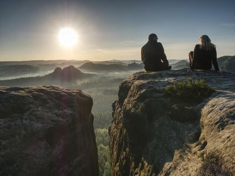 Silhouette woman and man shooting sunset on the top mountain. Relax time travel on holiday