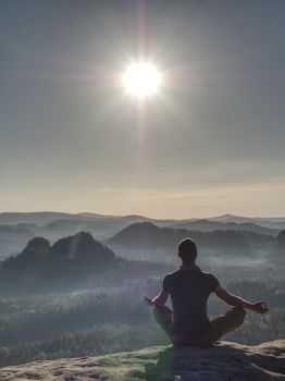 Sitting trekker in cowboy hat enjoy view with mountain Sunrise.