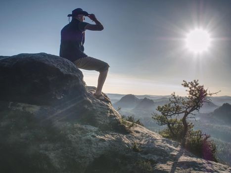 Trekker in cowboy hat enjoy view on the mountain with Beautiful Sunrise and sea of mist in the morning on Khao Luang mountain 