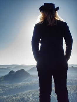 Successful woman hiker cheking the altitude on the top of sandstone sharp cliff edge. 