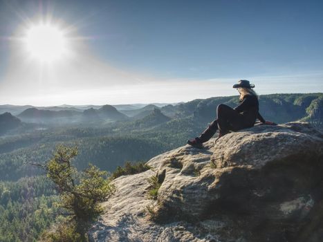 Cow woman hiker with hat and glassess  enjoying amazing valley landscapes view on a top of mountain.