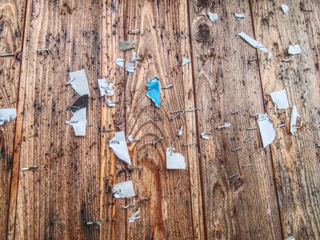 Scraps of paper on a wooden wall or  old wooden fence. Torn paper ad. cleaning ads