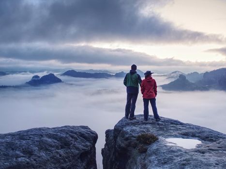 Romantic date in misty mountains. Man shows girlfriend something interesting in far distance.