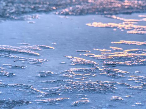 Natural winter icy background of defocused ice with copy space. Blue purple colors of ie floes